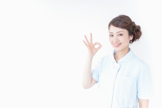 指で丸を作っている女性医療従事者